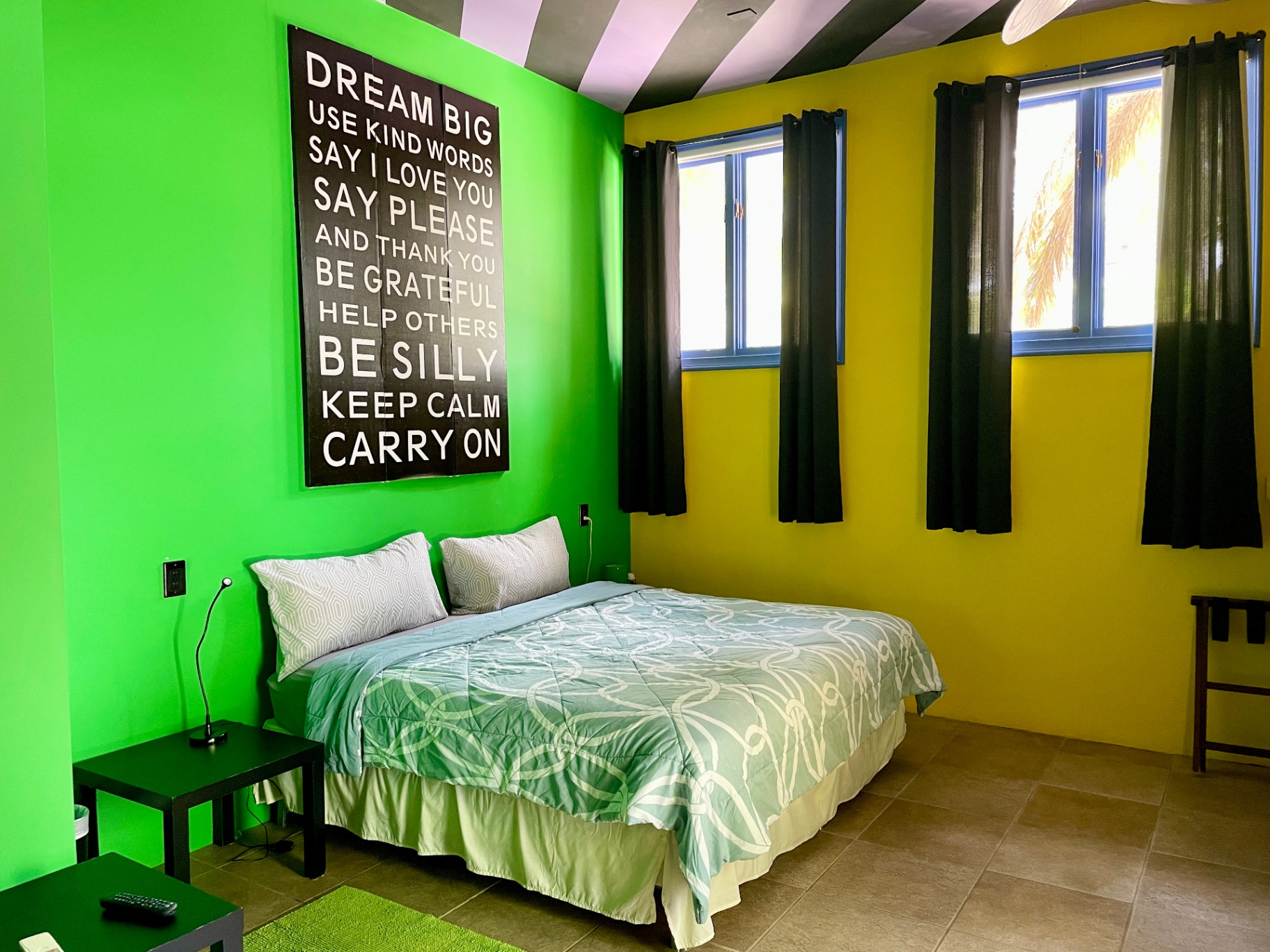 Green and yellow bedroom with 'Dream Big' wall art