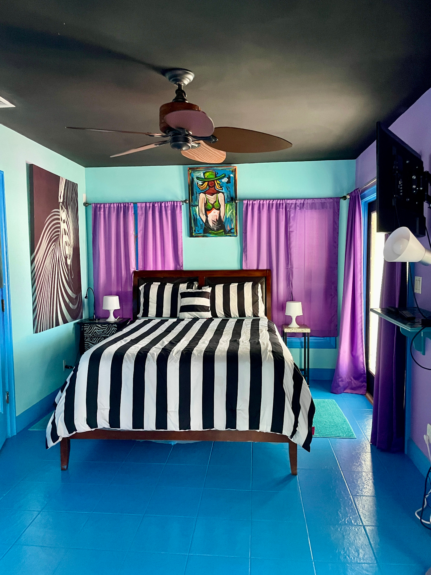 Bedroom with striped bedding, teal walls and purple curtains