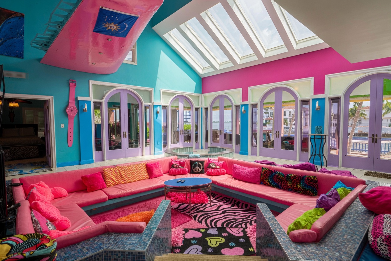 Sunken living room with pink sectional and arched waterfront doors