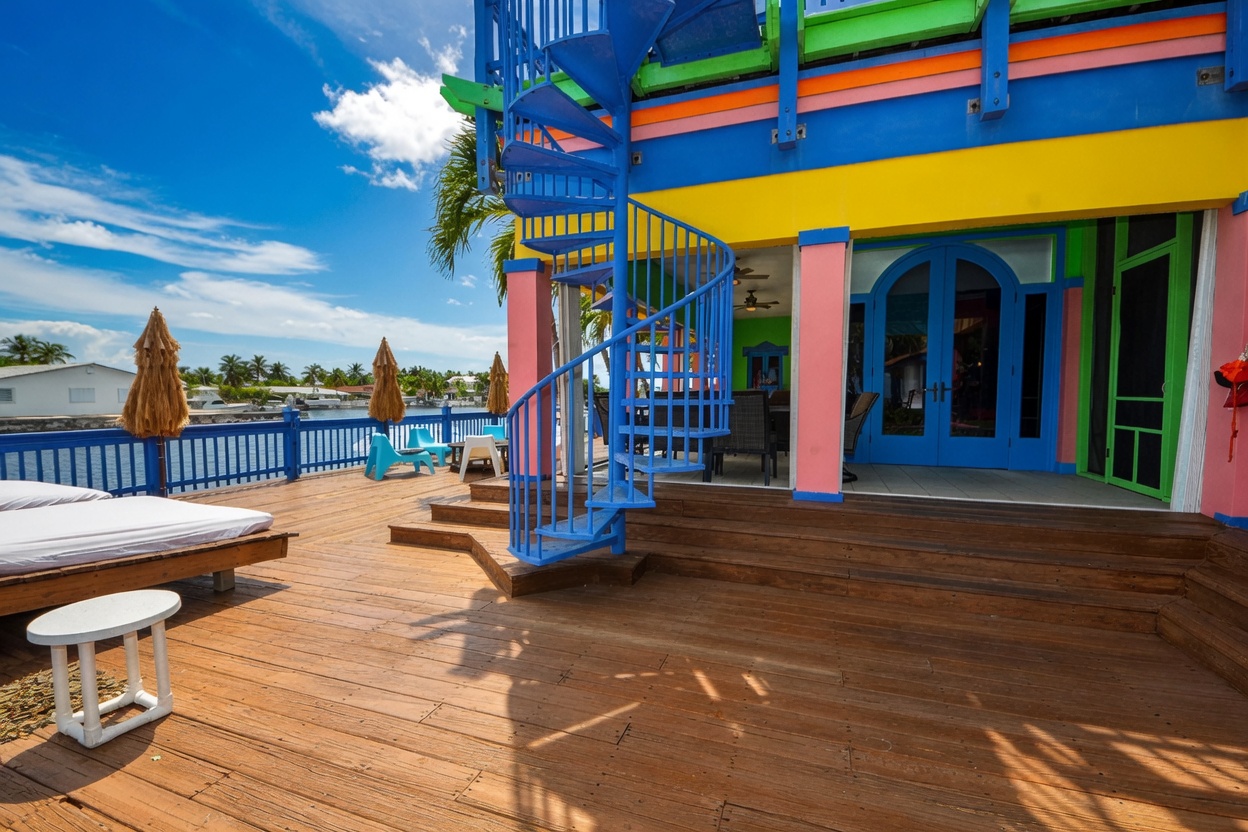Oceanfront deck with blue spiral staircase and colorful facade