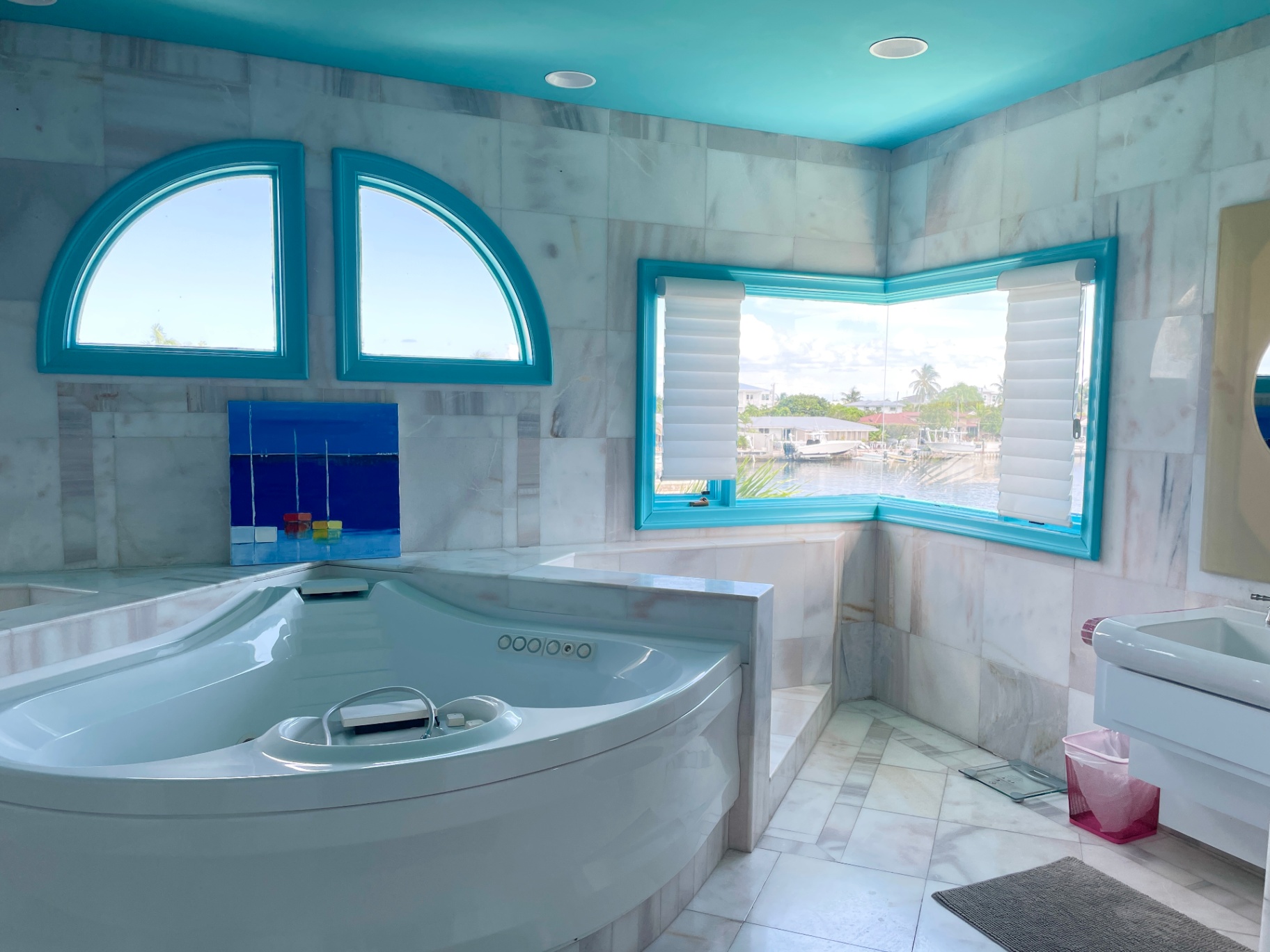 Marble bathroom with corner jacuzzi tub and waterfront view